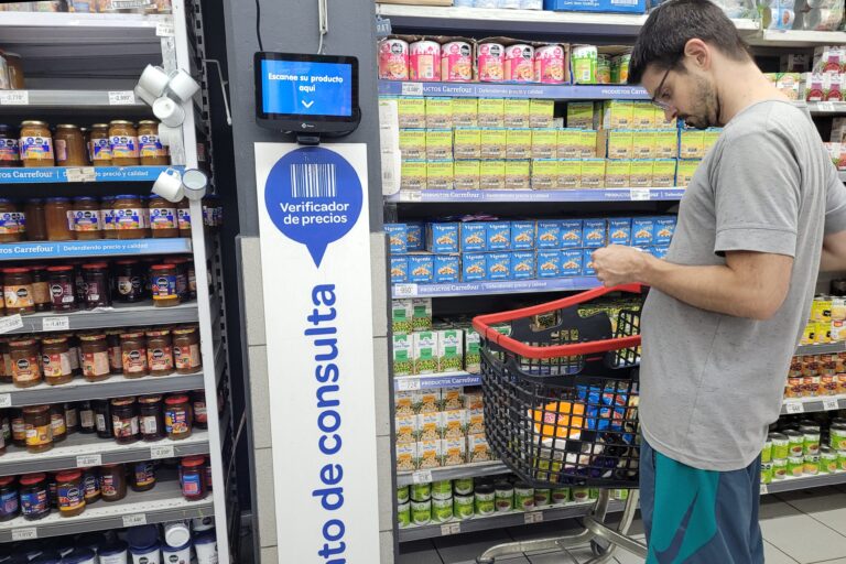 Góndola de supermercado con frutas y verduras, mostrando etiquetas de precios