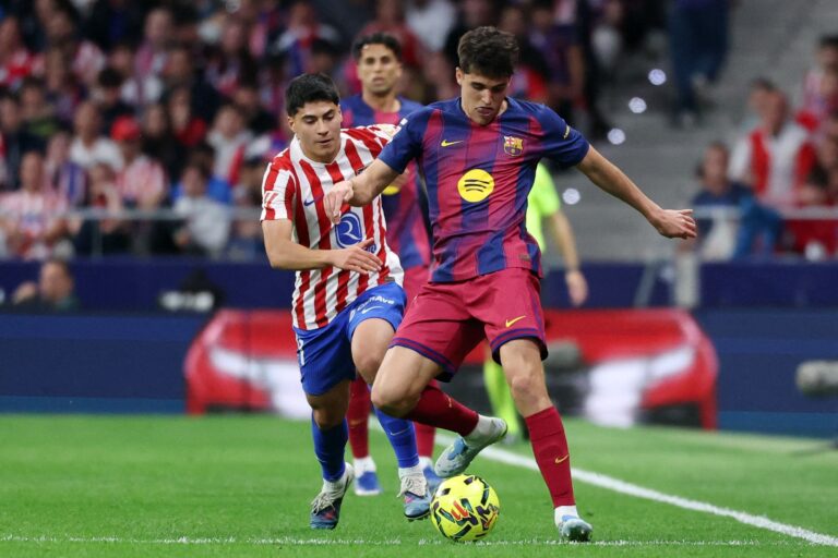 Los escudos del FC Barcelona y del Atlético de Madrid enfrentados, representando el partido de cuartos de final de la Champions League.