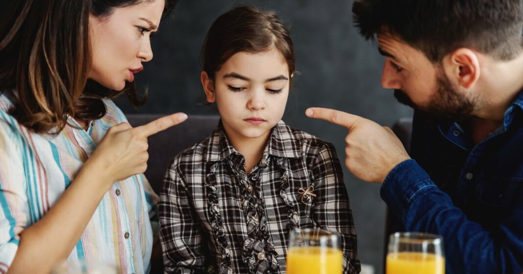 Padre conversando tranquilamente con su hijo pequeño en un entorno doméstico.