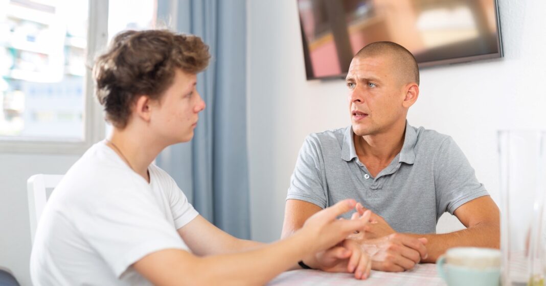 Padre y adolescente teniendo una conversación tranquila en el living de una casa