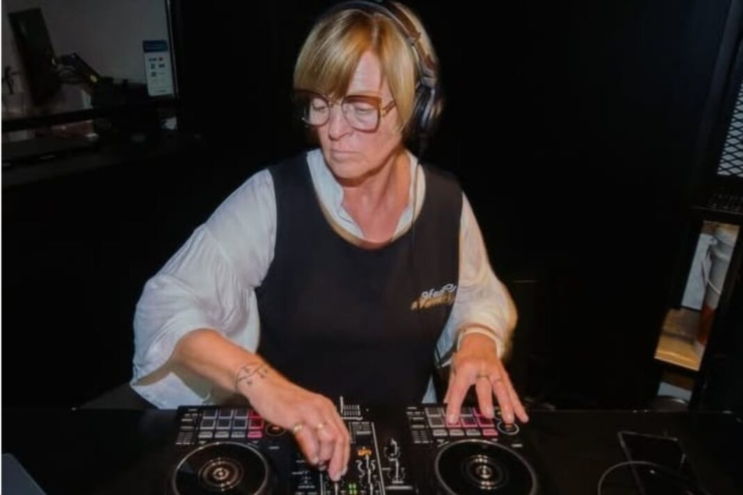 Diana Rumbo, una mujer adulta mayor, sonríe mientras manipula una consola de DJ en un geriátrico.