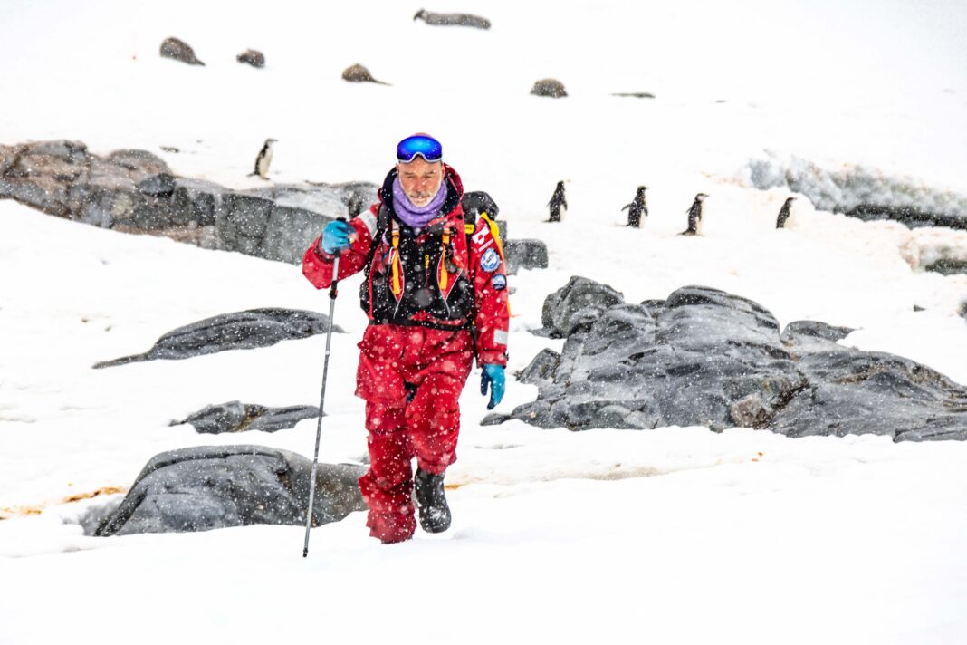 Fernando Tarapow en la Antártida, con pingüinos y paisaje nevado de fondo