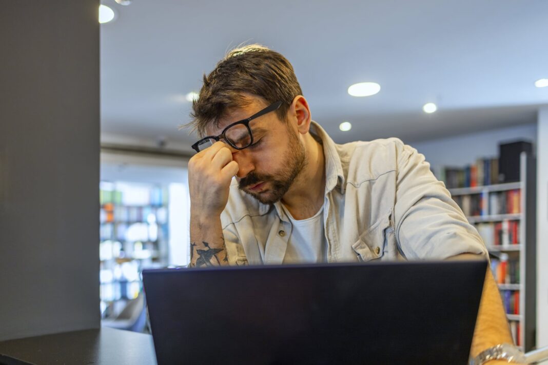 Hombre sosteniendo un boleto de lotería raspadito premiado, con expresión de sorpresa.