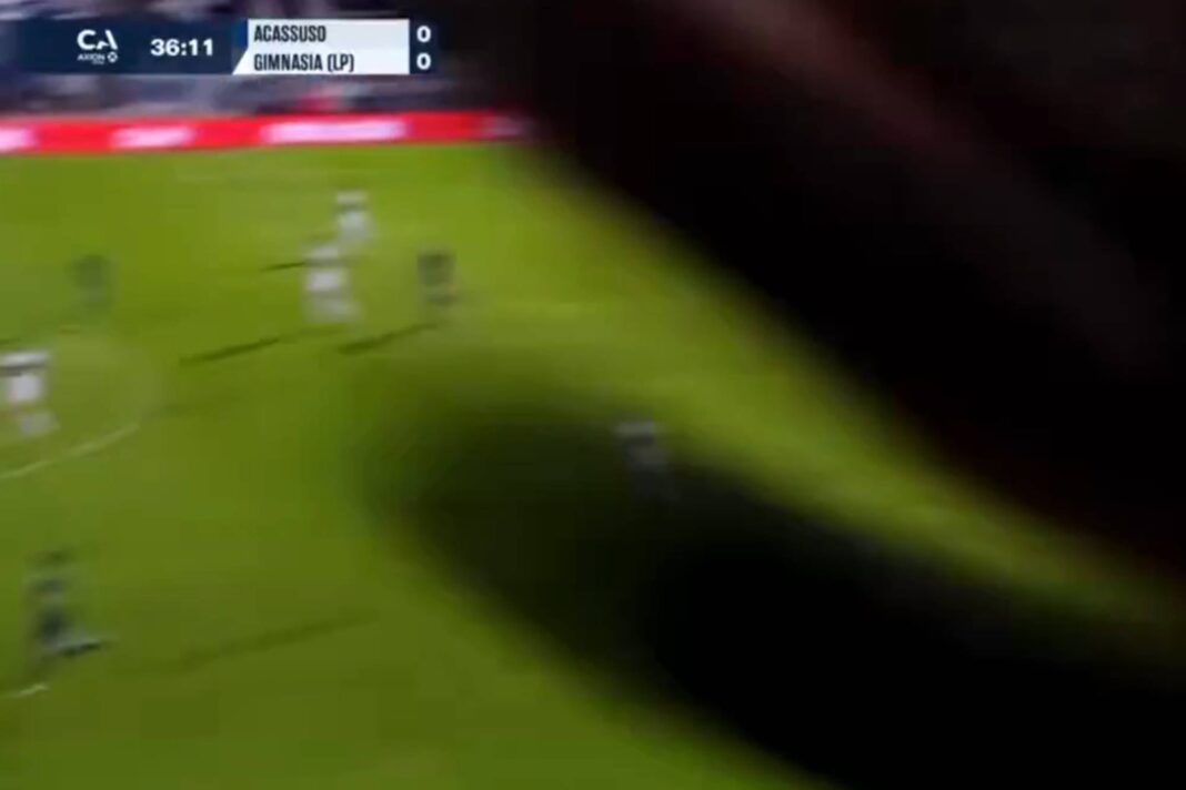 Hincha de Gimnasia filmándose con una cámara de TyC Sports durante el partido contra Acassuso