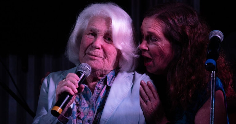 Mónica Cahen D'Anvers y Sandra Mihanovich en un escenario durante una presentación musical.