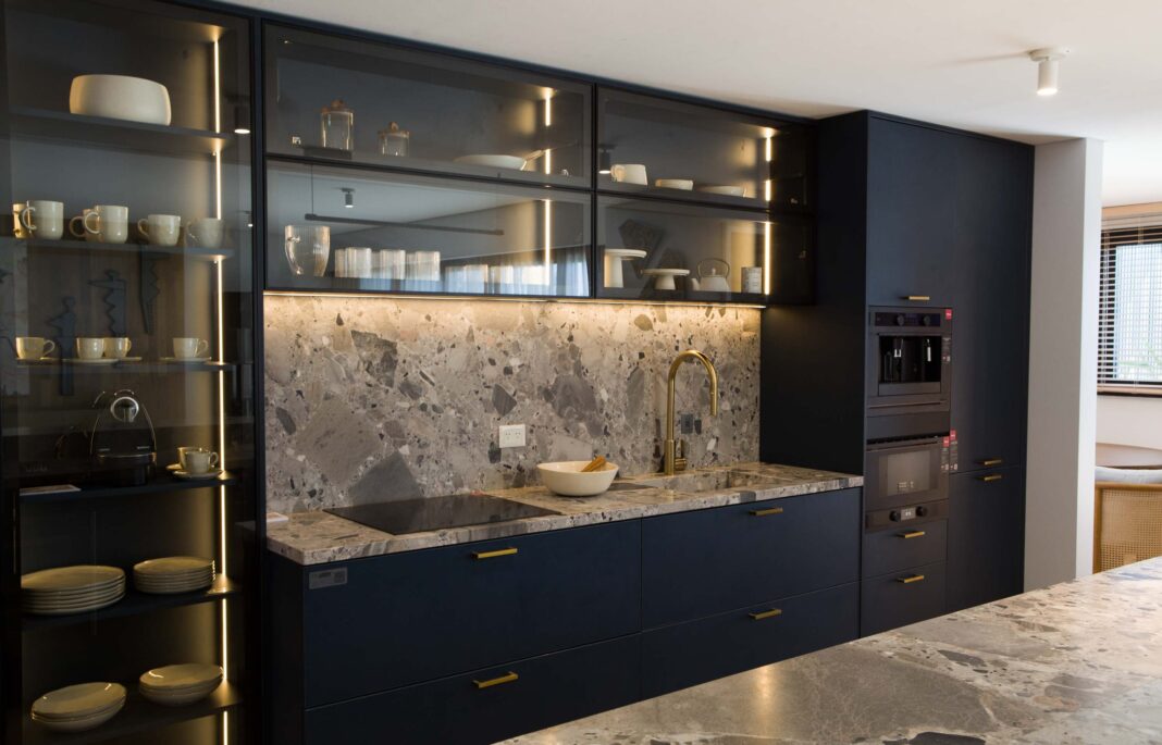 Arquitecto y cliente revisando planos de remodelación de una cocina moderna