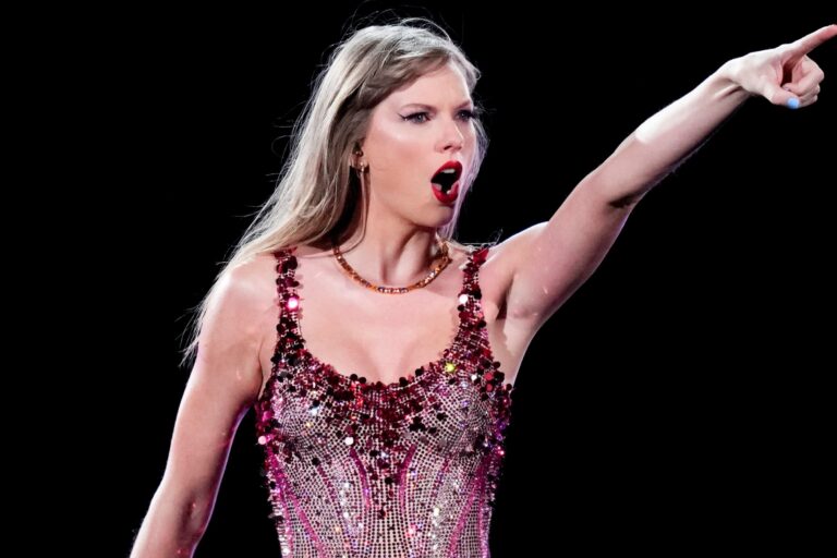 Taylor Swift en un escenario rosa sosteniendo una guitarra rosa