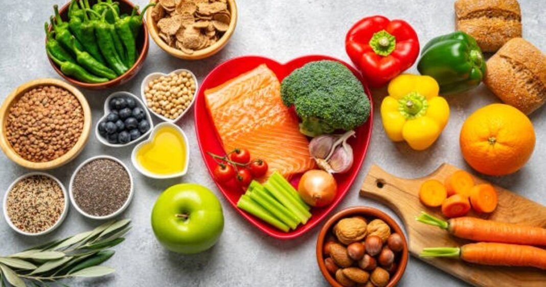 Plato con alimentos procesados y un hígado saludable al fondo, ilustrando la relación entre dieta y salud hepática