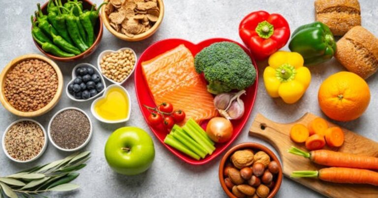 Plato con alimentos procesados y un hígado saludable al fondo, ilustrando la relación entre dieta y salud hepática