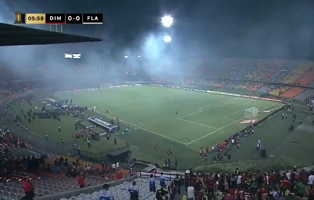 Tribunas del estadio Anastasio Girardot cubiertas por humo rojo durante el partido entre Independiente de Medellín y Flamengo