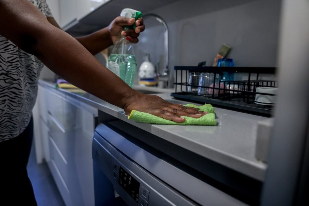 Mujer limpiando una mesa en una cocina