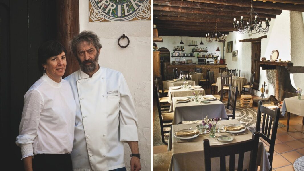 Interior del restaurante Arrieros en Linares de la Sierra, con chimenea y techo de madera