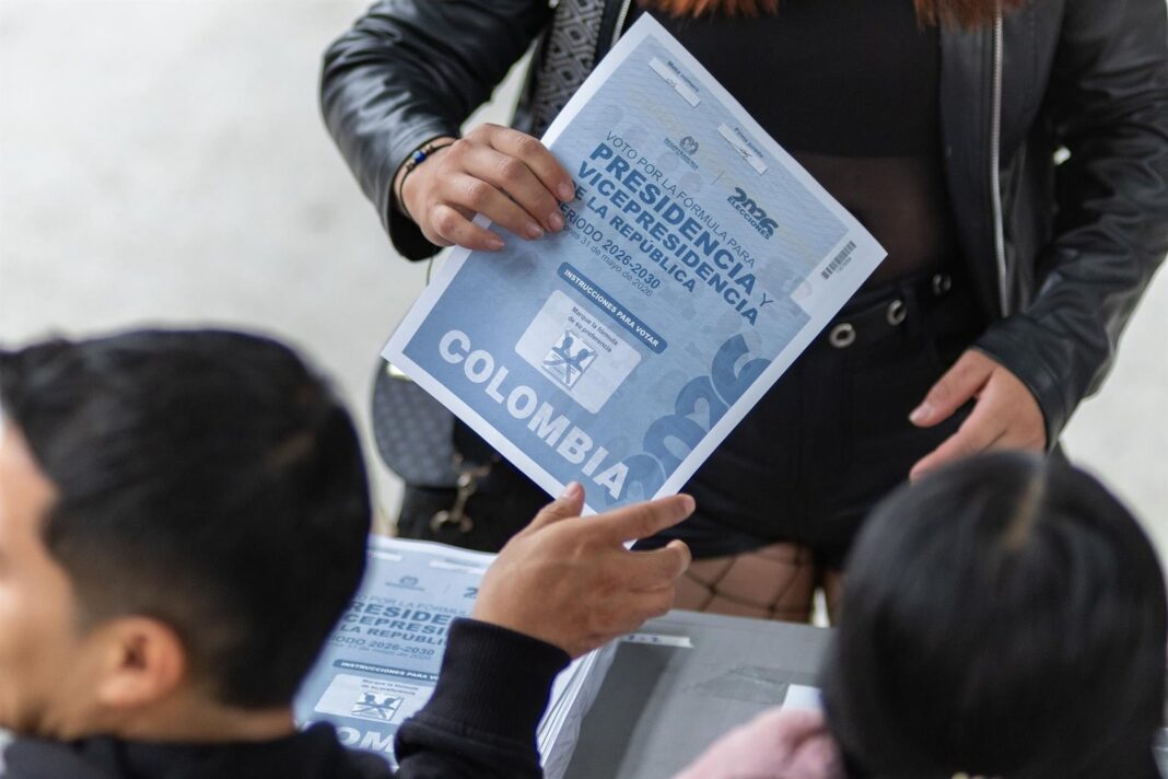 Urnas electorales en Colombia con bandera colombiana de fondo