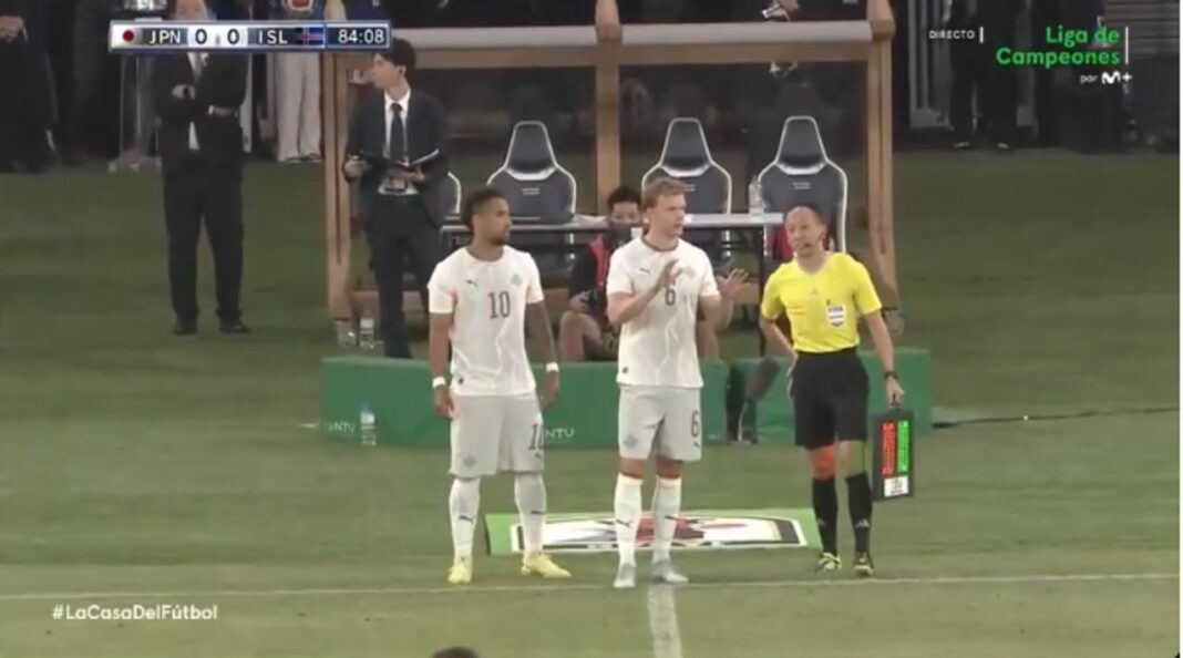 Árbitro mostrando tarjeta amarilla durante partido de fútbol