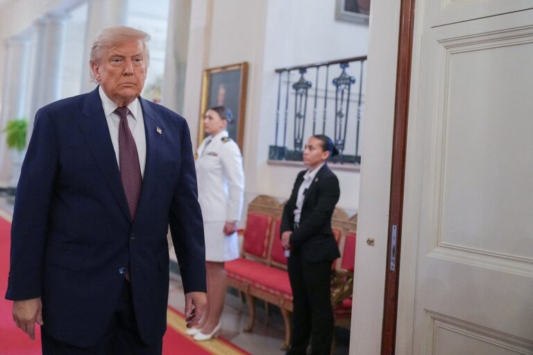 Donald Trump firmando un documento en el Palacio de Versalles