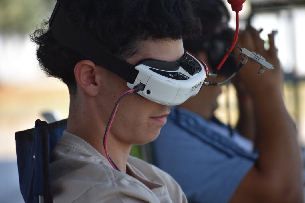 Dron de competición FPV volando a baja altura sobre un circuito con puertas LED