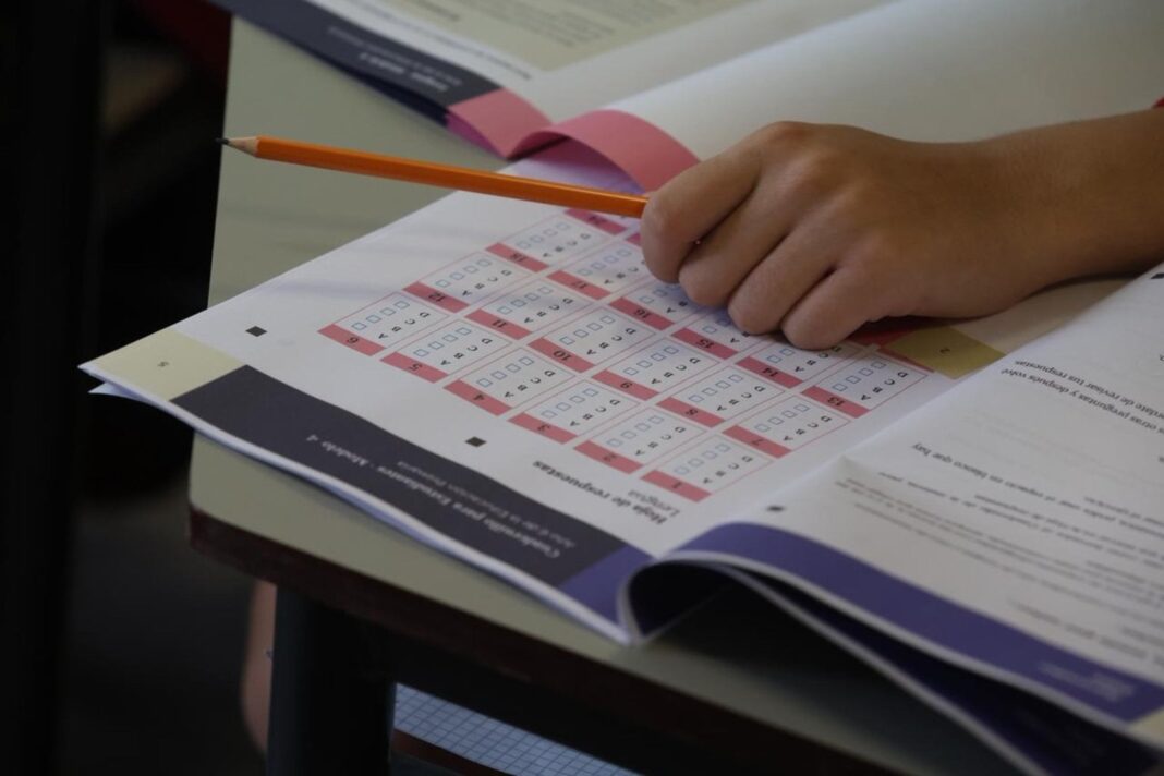 Estudiantes en un aula realizando una prueba escrita