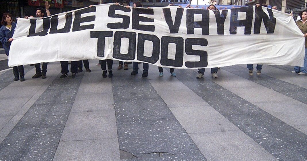 Personas caminando frente a una urna electoral en Argentina